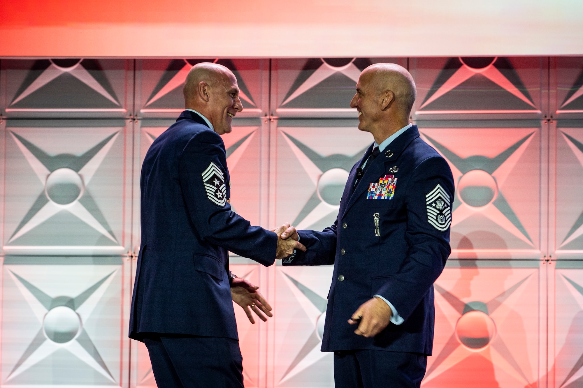 Chief Master Sgt. Jamie Newman, Air Mobility Command command chief, welcomes Chief Master Sgt. of the Air Force David Flosi to the stage during the 56th Annual Airlift/Tanker Association Symposium, Nov. 1, 2024, Grapevine, Texas. Flosi stressed the importance of Rapid Global Mobility and its vital role in an era of Great Power Competition. (U.S. Air Force photo by Staff Sgt. Dalton Williams)