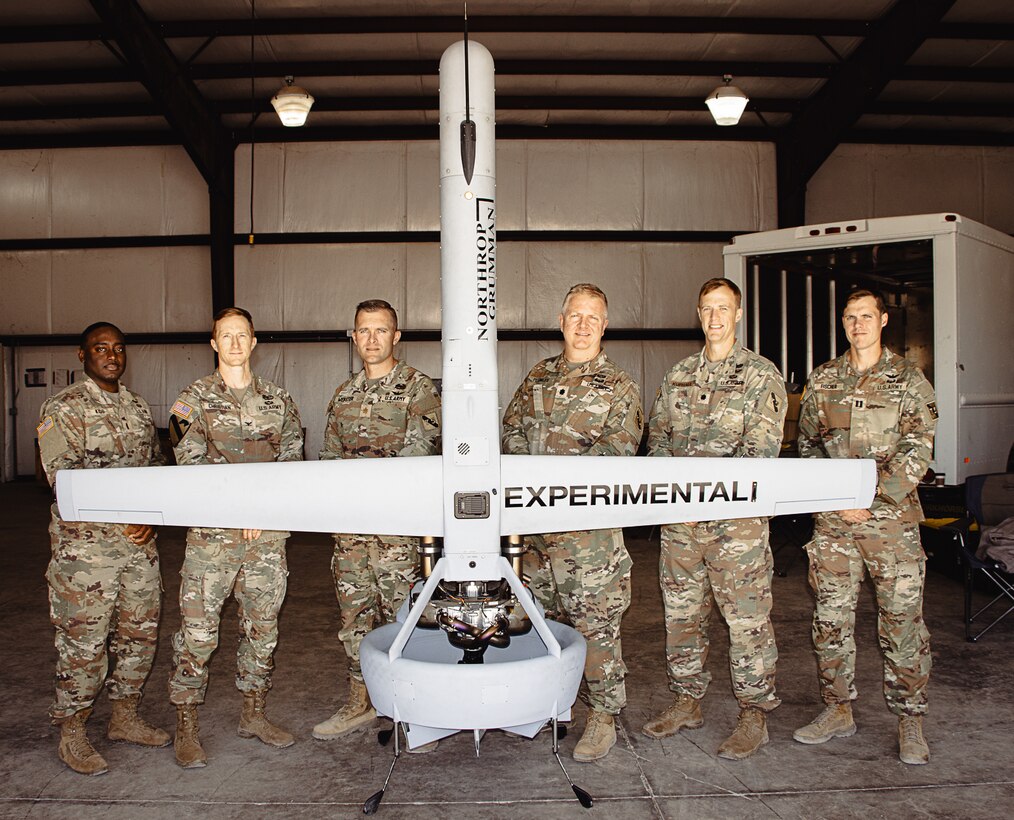 Soldiers from 3rd Brigade Command Team, 101st Airborne Division, and Army Applications Group, 75th U.S. Army Reserve Innovation Command, gather behind a V-BAT, a Vertical Take-Off and Landing unmanned aerial vehicle, after a successful demonstration of its autonomous capabilities Sept. 17, 2024, at Yuma Proving Ground, Arizona