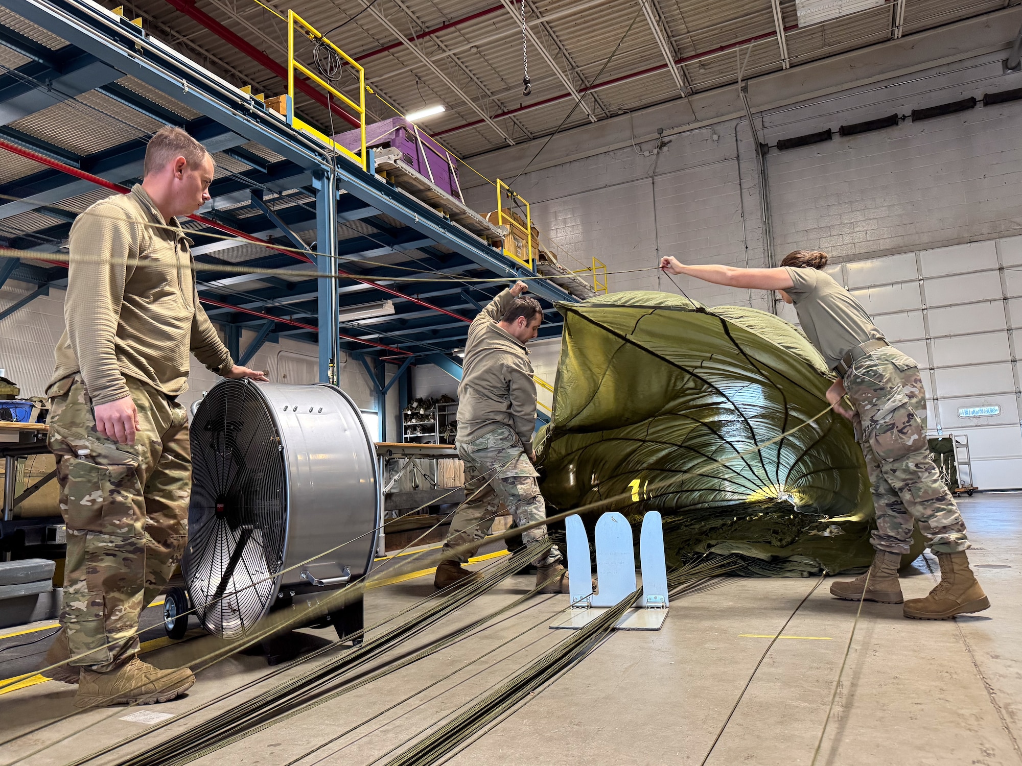 Under the supervision of qualified riggers, Airmen in the air transportation specialist career field from the 193rd Special Operations Logistics Readiness Squadron take part in rigging parachutes for training airdrops using the wing’s new MC-130J Commando II aircraft, Nov. 2, 2024.