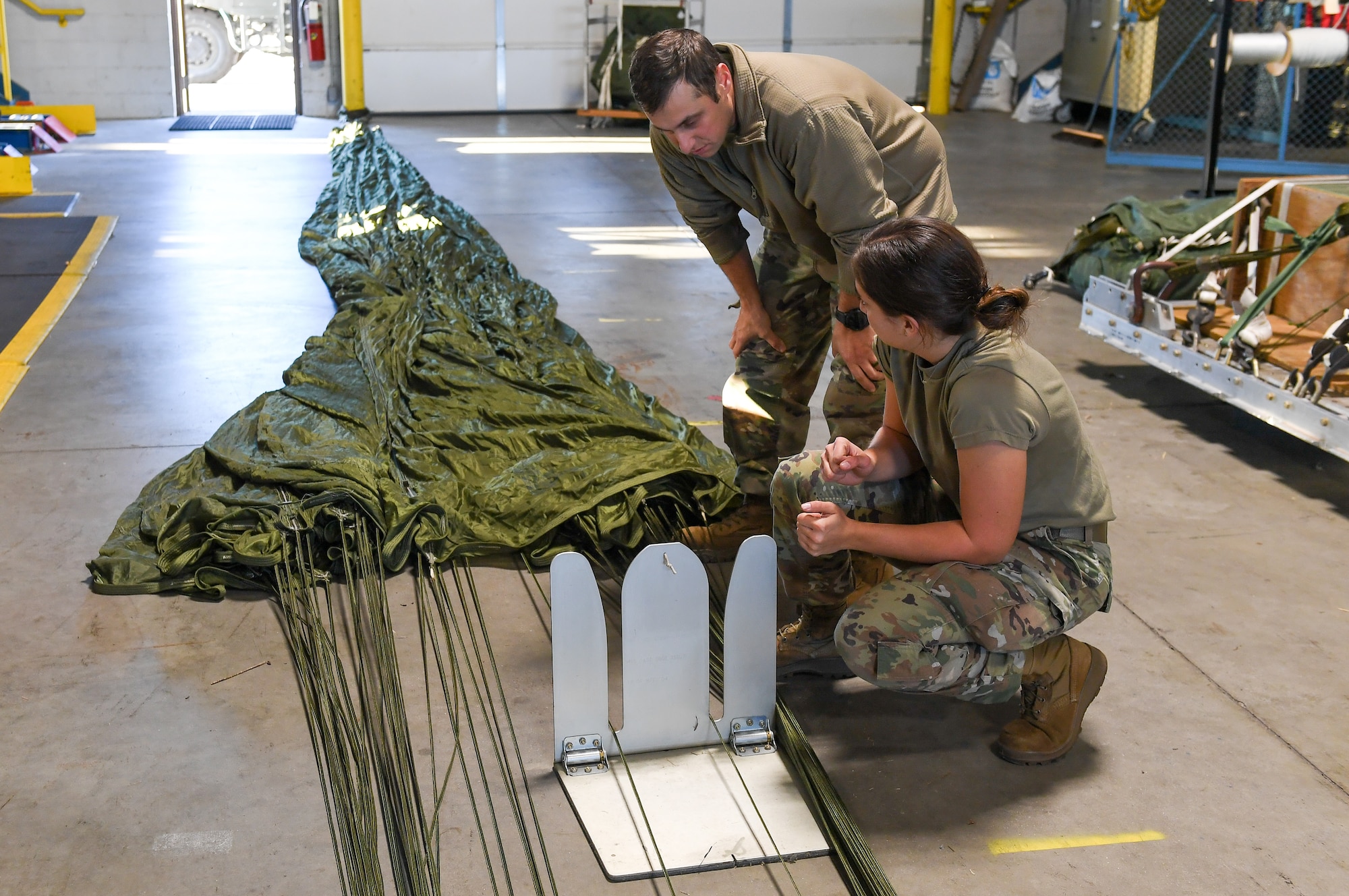 Under the supervision of qualified riggers, Airmen in the air transportation specialist career field from the 193rd Special Operations Logistics Readiness Squadron take part in rigging parachutes for training airdrops using the wing’s new MC-130J Commando II aircraft, Nov. 2, 2024.
