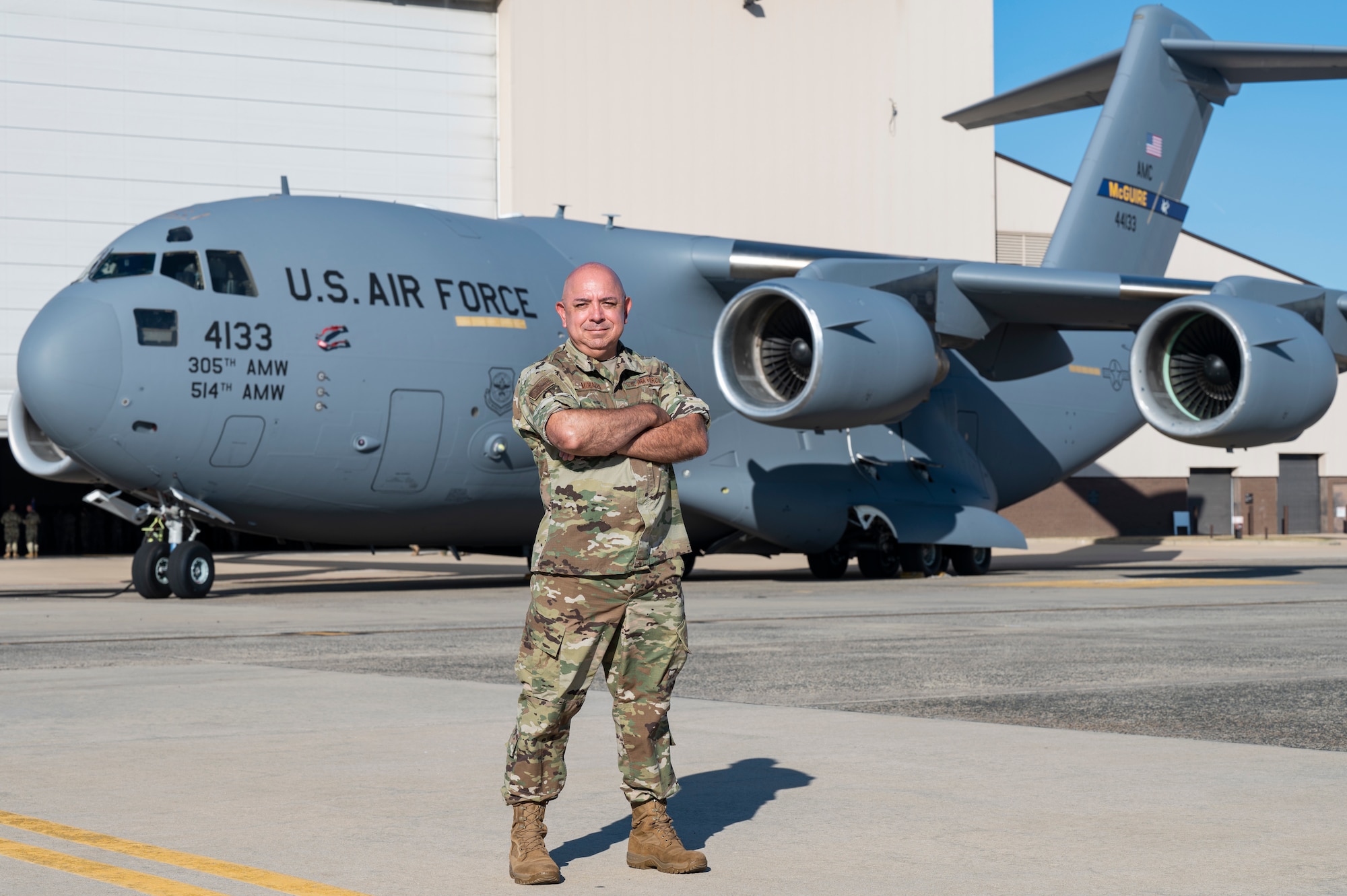 U.S. Air Force Master Sgt. Aluin Morales, a public affairs speciliast with the 514th Air Mobility Wing poses in front of a C-17 Globemaster III at Joint Base McGuire-Dix-Lakehurst, N.J., on Oct. 6, 2024.