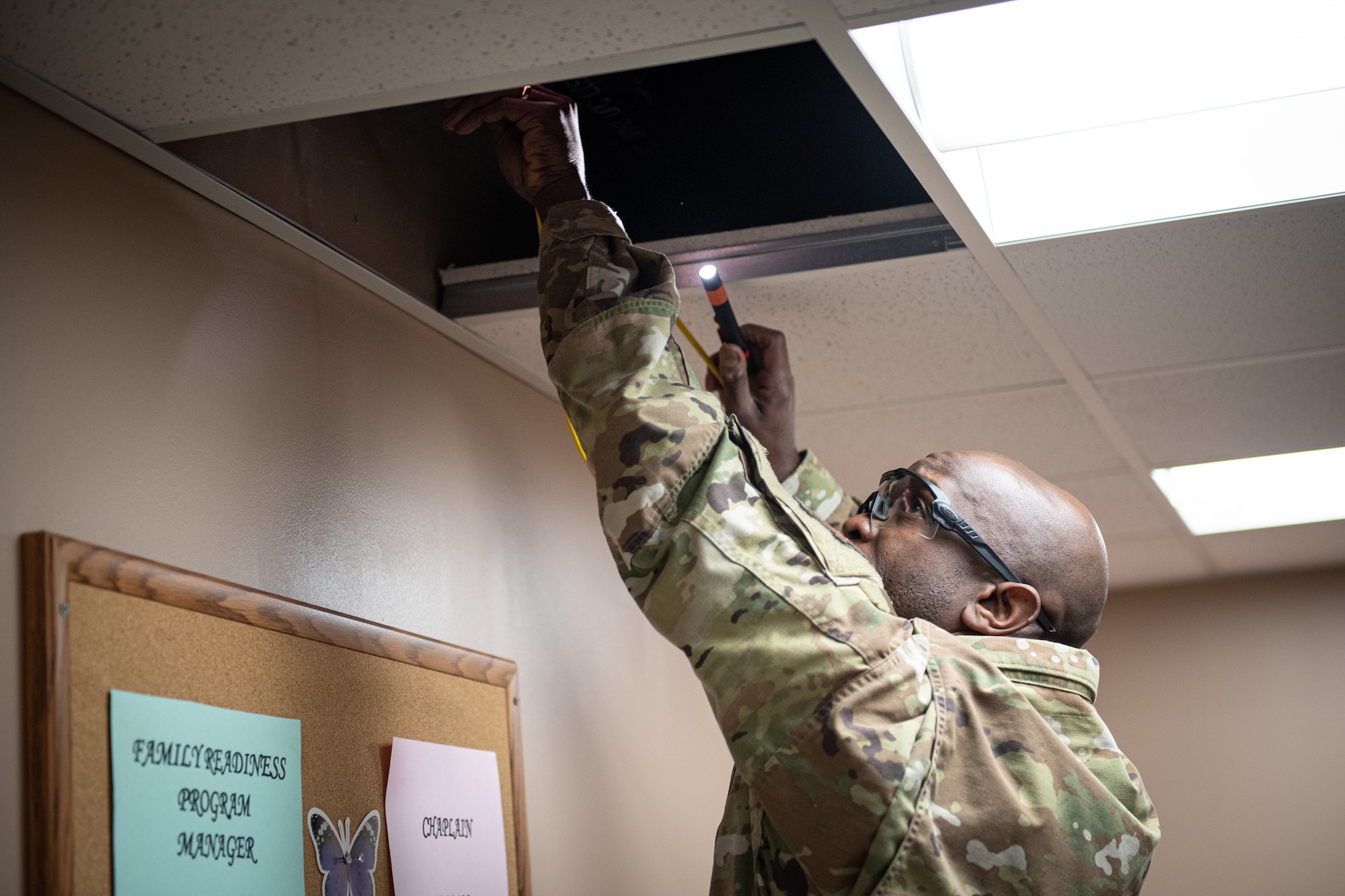 Tech. Sgt. Jermaine Smalls, a cyber transport specialist with the 193rd Special Operations Communications Squadron, runs a fiber optic cable through the ceiling at Middletown, Pennsylvania, Nov. 2, 2024.