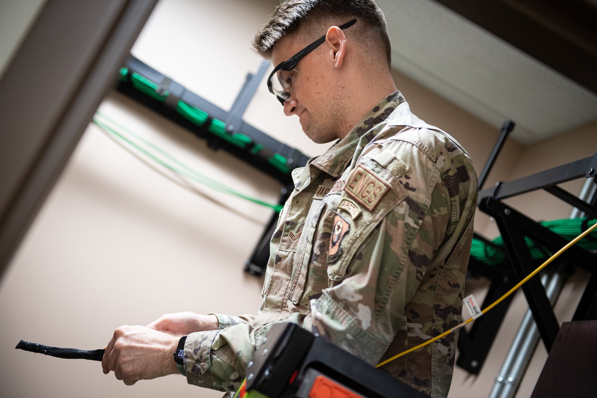 Senior Airman Zach Soles, a cyber transport specialist with the 193rd Special Operations Communications Squadron, runs a fiber optic cable to a communications closet at Middletown, Pennsylvania, Nov. 2, 2024.