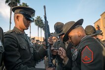 U.S. Marine Corps Staff Sgt. Francisco Rosario, right, and Staff Sgt. Christian Duarte, center, both drill instructors with Kilo Company, 3rd Recruit Training Battalion, inspect a Marines M16A4 service rifle during a battalion commander inspection at Marine Corps Recruit Depot San Diego, California, Oct. 23, 2024. The Battalion Commander’s Inspection surveys new Marines for knowledge, bearing, and attention to detail as one of their last tests before graduating. (U.S. Marine Corps photo by Cpl. Sarah M. Grawcock)