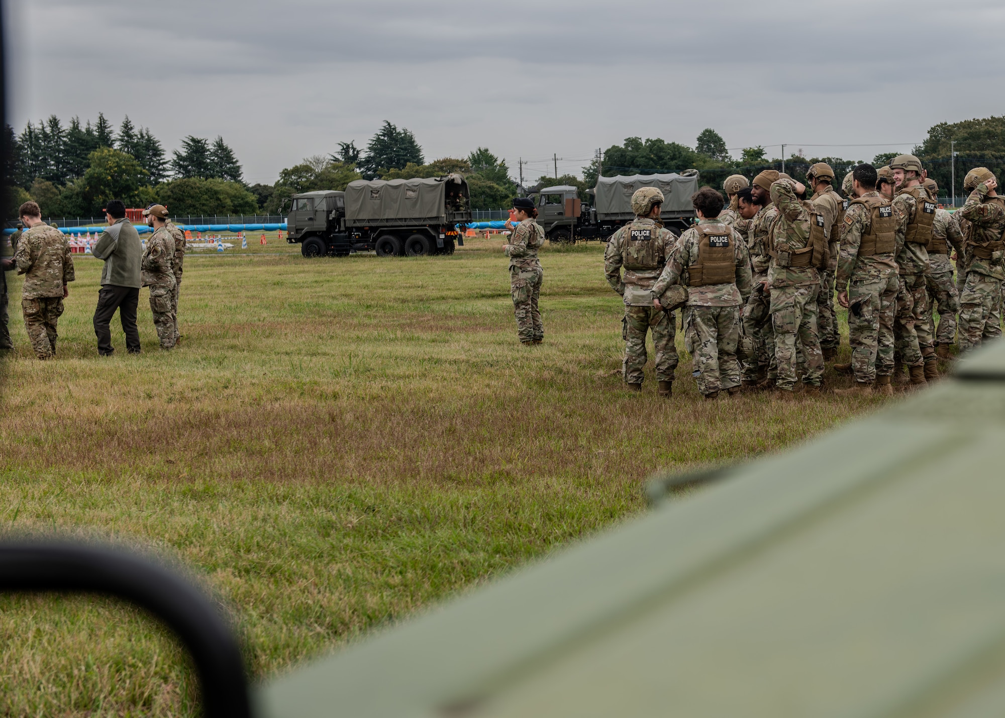 A group of Airmen and Japan Ground Self Defense Force members stand in a field.