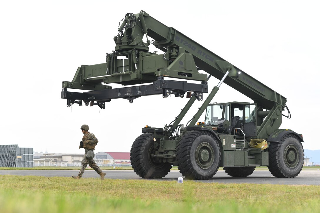U.S. Marine Corps Cpl. Valle Eduardo, an engineer equipment operator with Marine Wing Support Squadron 171, Marine Aircraft Group 12, 1st Marine Aircraft Wing, walks with a Kalmar RT240 rough terrain container handler to a simulated aircraft recovery site during exercise Keen Sword 25, Marine Corps Air Station Iwakuni, Oct. 31, 2024. Keen Sword is a biennial, joint and bilateral field-training exercise involving U.S. military and Japan Self-Defense Force personnel, designed to increase readiness and interoperability while strengthening the ironclad U.S.-Japan alliance. (U.S. Marine Corps photo by Pfc. Saul Hernandez)