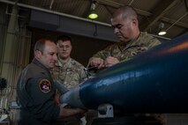 U.S. Air Force Col. Matthew Kenkel, left, 35th Fighter Wing (FW) deputy commander, Senior Airman Victor Sanchez-Robles, center, 35th Maintenance Squadron Munitions Flight conventional munitions crew chief, and U.S. Air Force Chief Master Sgt. David Najera, 35th FW command chief, assemble an inert GBU-38 bomb.