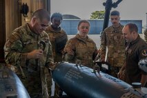 The 35th Fighter Wing (FW) command team takes part in assembling inert GBU-38 bombs.