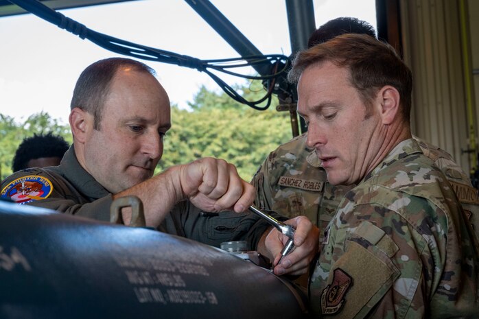 U.S. Air Force Col. Paul Davidson, right, 35th Fighter Wing (FW) commander, and U.S. Air Force Col. Matthew Kenkel, 35th FW deputy commander, build an inert GBU-38 bomb during a Wild Weasel Walk-through.