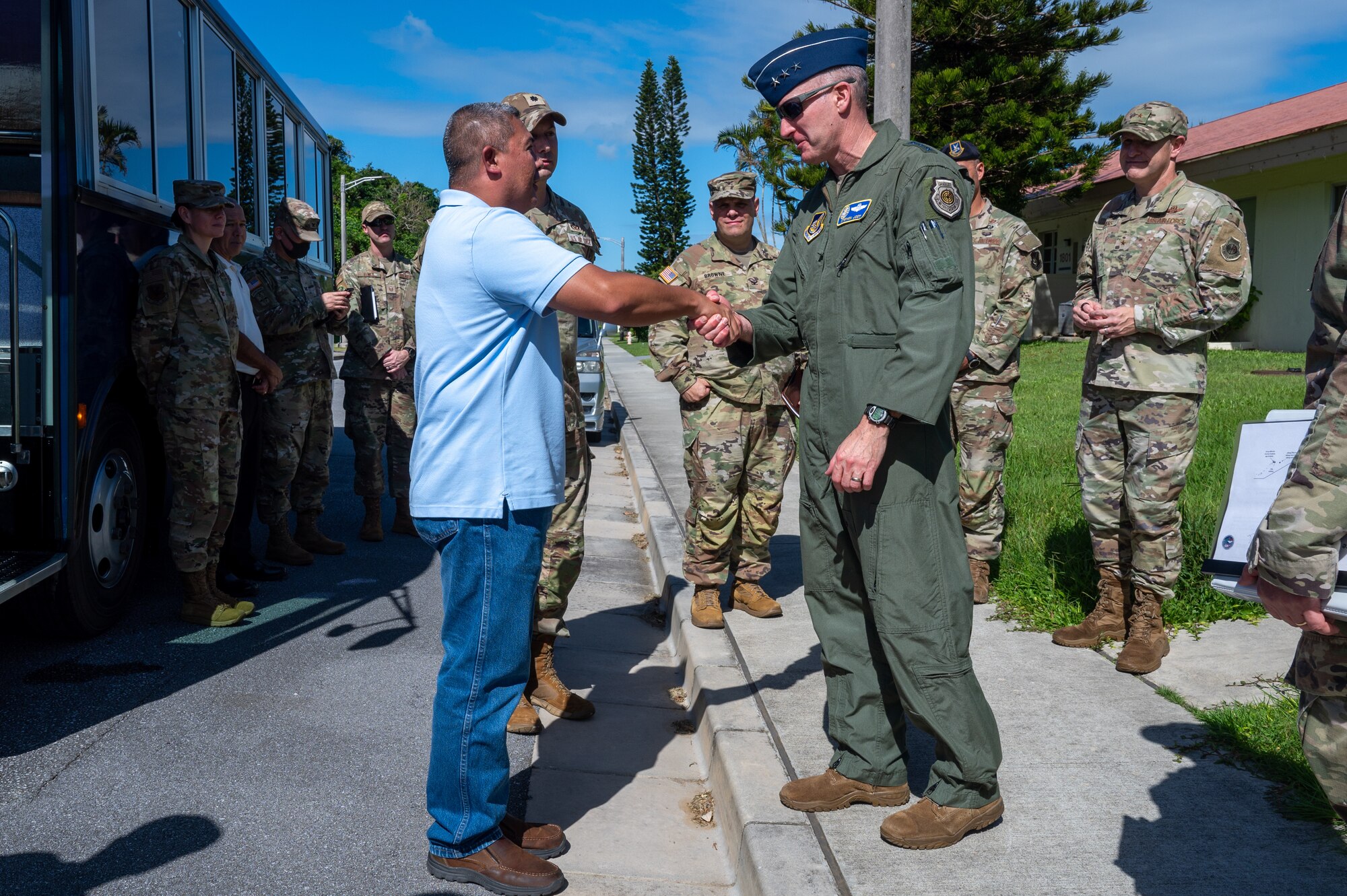 Military member shakes hand with coin in his hand as an award to the service supervisor.