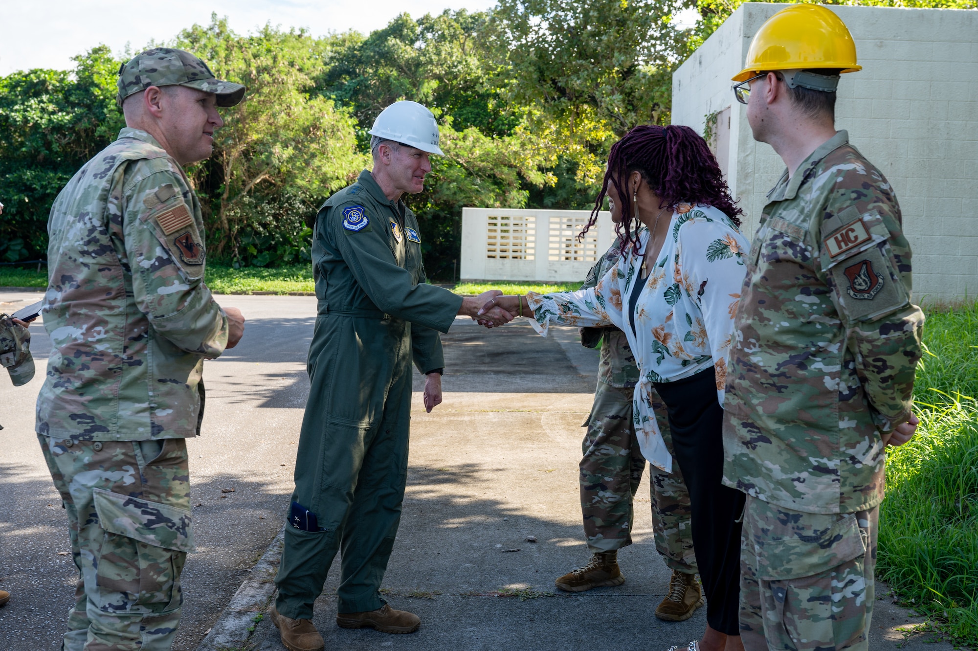 Military member shakes hand with a coin to a civilian member