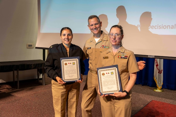 241010-JC800-1038 BETHESDA, Md. (Oct. 10, 2024) - Capt. William Deniston, lead inspector for the Medical Inspector General, awards a certificate of recognition to Lt. Cmdr. Alaina Downey and Lt. Cmdr. Angela Healy, MEDIG command coordinators, during an outbrief for MEDIG. (U.S. Navy Photo by Mass Communication Specialist 1st Class Heath Zeigler)