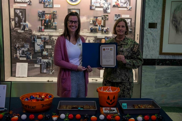 241101-JC800-1004 BETHESDA, Md. (Nov. 1, 2024) - Capt. Katharine Shobe, commanding officer of Naval Medical Leader and Professional Development Command, presents Mrs. Shannon Labarbera, command ombudsman, with a certificate of recognition for her management of the ombudsman program during the Medical Inspector General Inspection. (U.S. Navy Photo by Mass Communication Specialist 1st Class Heath Zeigler)