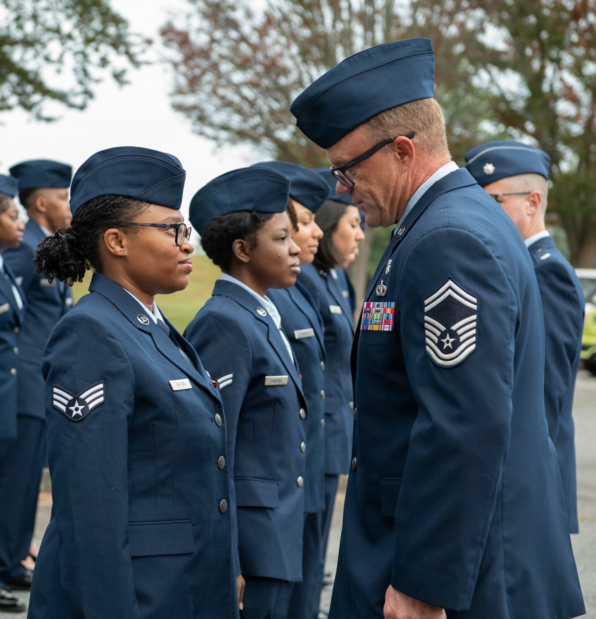 A man inspects uniforms.