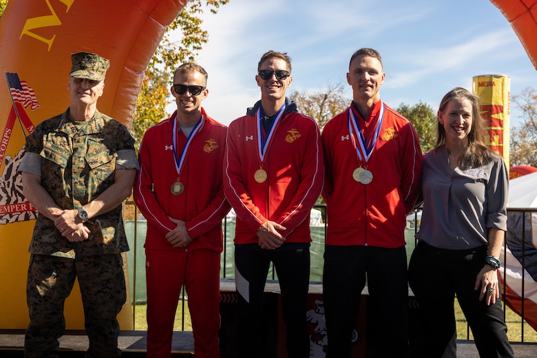 The top three finishers for the Marine’s men team pose for a group photo after they receive medals during an award ceremony in Arlington, Virginia, Oct. 27, 2024. Participants from around the world raced on the monumental MCM course through Washington, D.C., finishing at the Marine Corps War Memorial in Arlington, Virginia. The event was a celebration of every finisher’s honor, courage, and commitment to training for and completing the marathon. (U.S. Marine Corps photo by Cpl. Darien Wright)