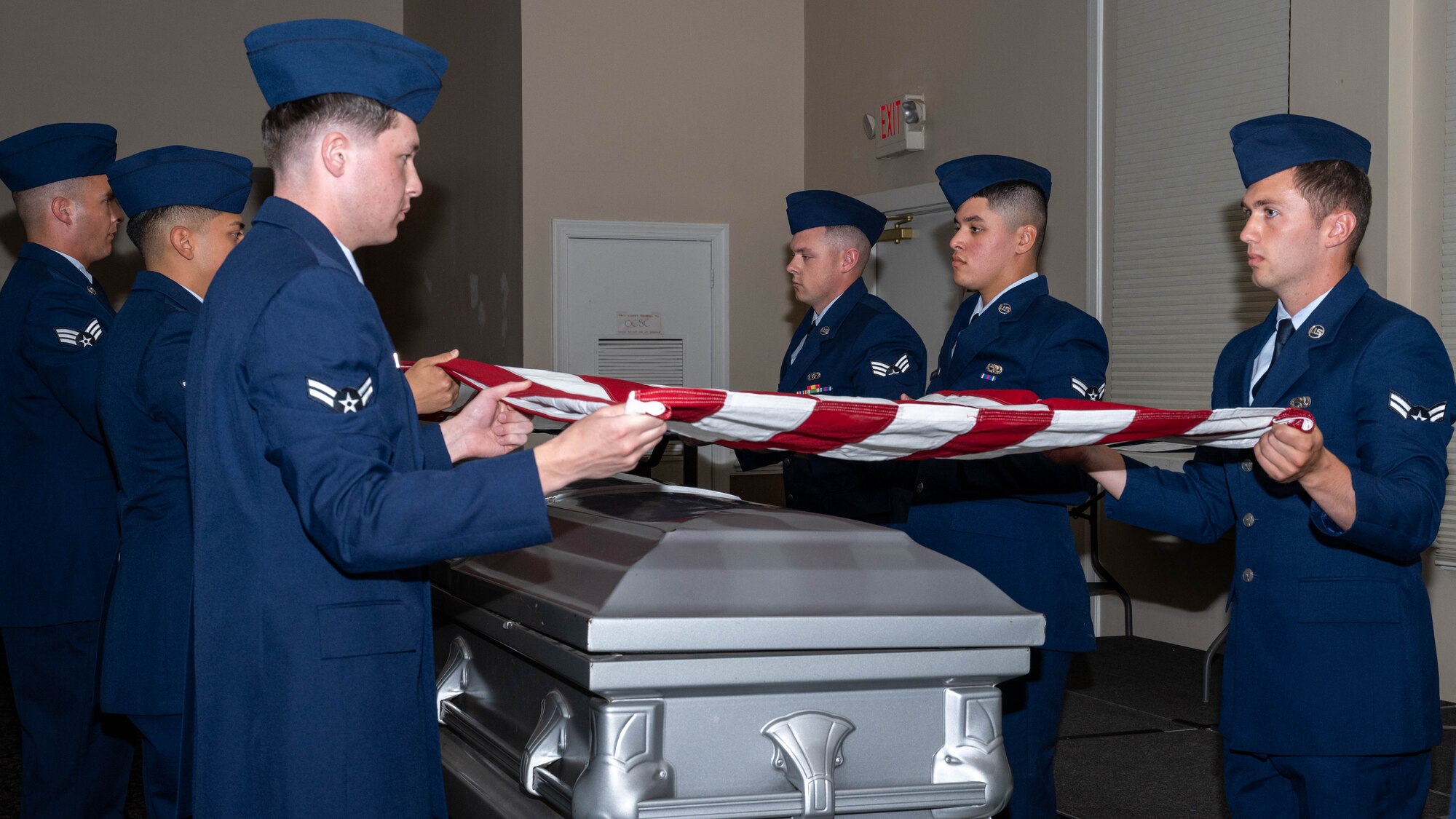 Seymour Johnson Air Force Base Honor Guard graduates demonstrate a six-man flag-fold during an honor guard graduation ceremony.