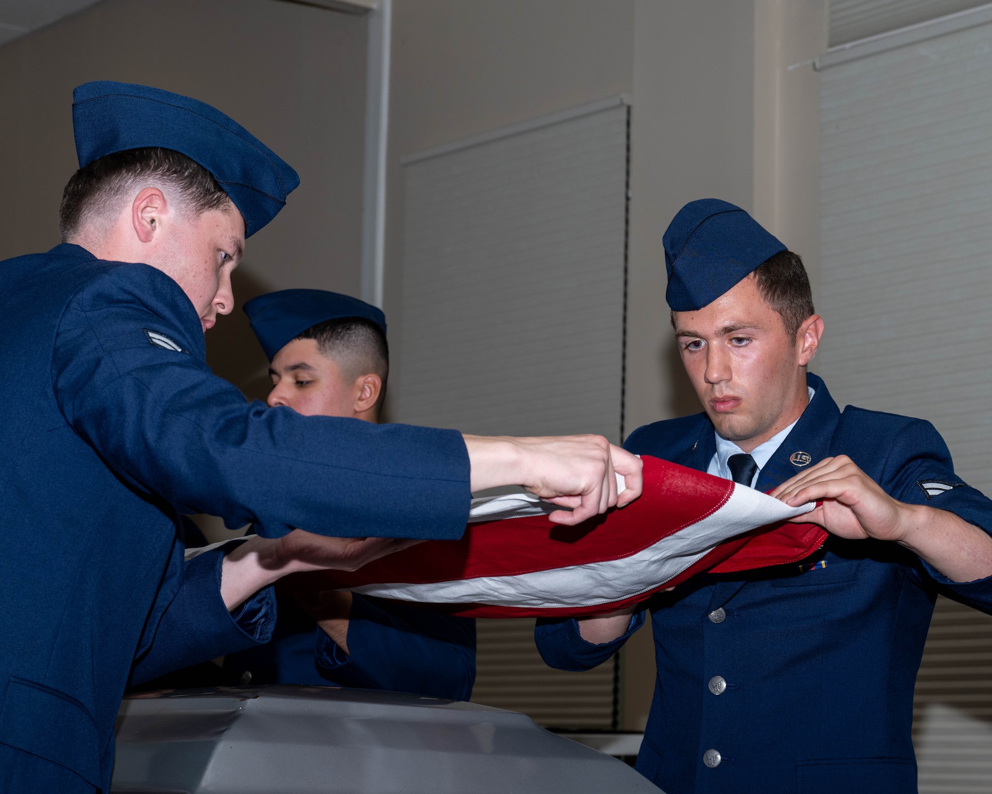 Seymour Johnson Air Force Base Honor Guard graduates demonstrate a six-man flag-fold during an honor guard graduation ceremony.