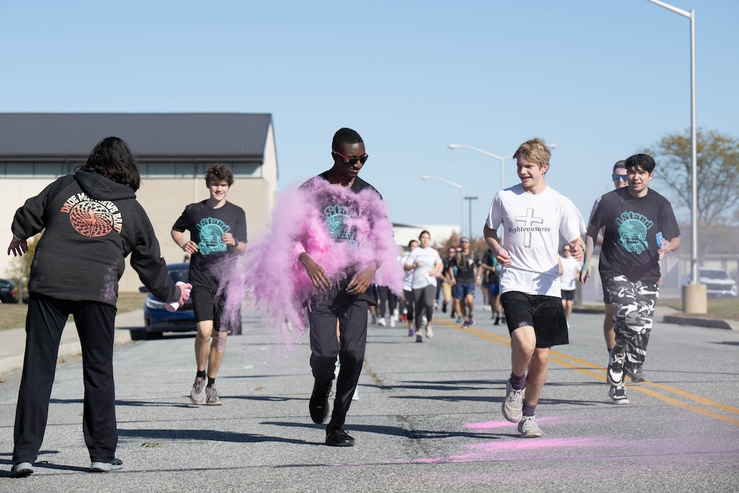 Members of Team Dover get blasted with powder during a color run at Dover Air Force Base, Delaware, Oct. 18, 2024. This year’s run was hosted by the Dover AFB Sexual Assault Prevention and Response team and the Family Advocacy Program to bring awareness and prevention to sexual assault and domestic violence. The annual run raises attention to the signs of assault and violence, and the agencies that are geared to help Airmen and their families. (U.S. Air Force photo by Mauricio Campino)