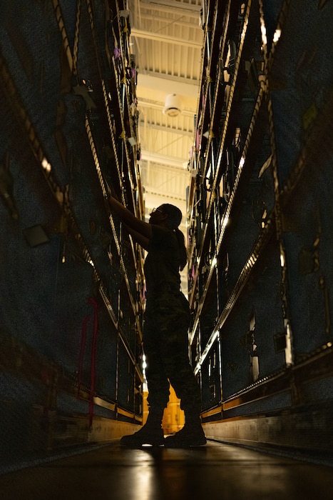 U.S. Airman Emma Sorrell, 436th Operation Support Squadron Aircrew Flight Equipment technician, reaches for a box on a shelf at Dover Air Force Base, Delaware, Nov. 1, 2024. The AFE team provides inspections and maintenance for flight safety equipment such as parachutes, emergency escape slides and life rafts for the C-5M Super Galaxy and C-17 Globemaster III. (U.S. Air Force photo by Airman 1st Class Liberty Matthews)