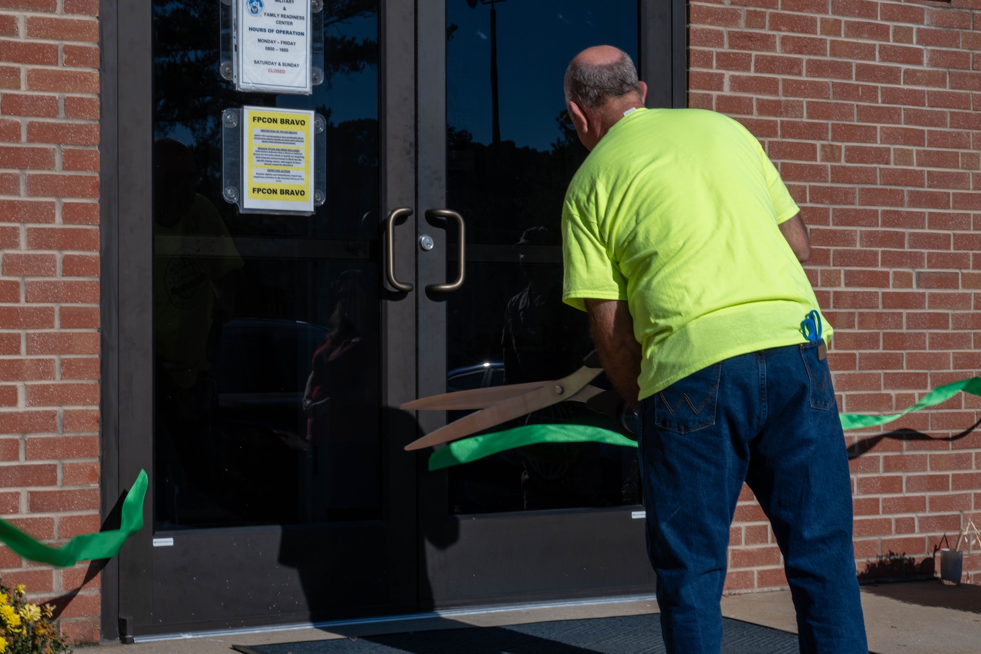 Jeffrey Craver, 4th Force Support Squadron Military and Family Readiness Center flight chief, cuts a ribbon during the grand reopening ceremony.