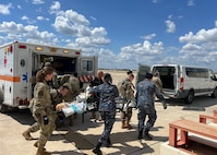 Royal Thai Air Force nurses assist U.S. Air Force medical personnel during a patient transport training exercise on the flight line at Kelly Airfield in San Antonio, Texas.