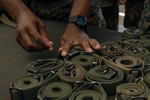 A U.S. Marines with India Company, 3rd Recruit Training Battalion, organizes rifle slings during a M16A4 service rifle de-issue at Marine Corps Recruit Depot San Diego, California, Oct. 23, 2024. After carrying their rifles throughout recruit training the new Marines will properly clean and de-issue their rifles to extend the life of the rifles and allow more time to maintain them for future recruits. (U.S. Marine Corps photo by Cpl. Sarah M. Grawcock)
