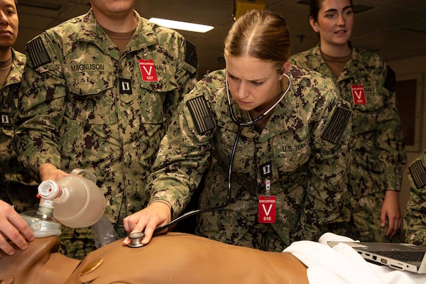 241017-N-KC192-1089 NORFOLK, Va. (Oct. 17, 2024) Lt. Sloane Spencer, a general dentist assigned to Sewells Point Branch Medical Clinic, uses a stethoscope to examine a simulation manikin during dental officer triage training aboard the Wasp-class amphibious assault ship USS Iwo Jima (LHD 7), Oct. 17, 2024. Over the course of three days, Army and Navy dental officers from Iwo Jima, Navy Medicine Readiness and Training Command (NMRTC) Portsmouth and Fort Gregg-Adams Dental Clinic Command conducted mass casualty, tactical combat casualty care, and triage training. (U.S. Navy photo by Mass Communication Specialist 2nd Class Levi Decker)