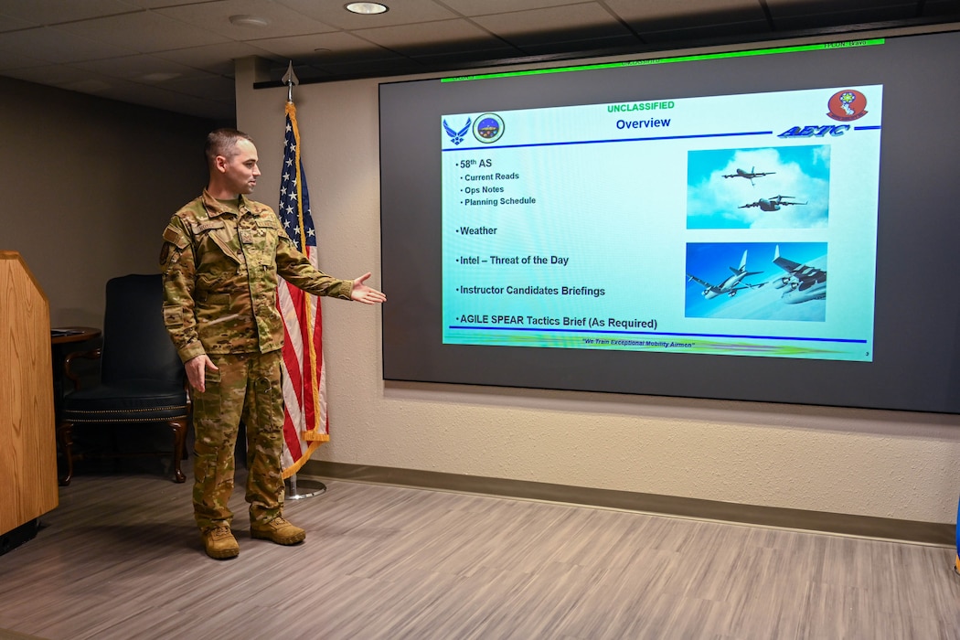 U.S. Air Force Senior Airman Garrett Royce, 58th Airlift Squadron (AS) instructor loadmaster, conducts a morning brief at Altus Air Force Base, Oklahoma, Oct. 28, 2024. Royce gives briefs daily to 58th AS student pilots, which includes weather, flying schedules, and current operation notes. (U.S. Air Force photo by Airman 1st Class Jonah Bliss)