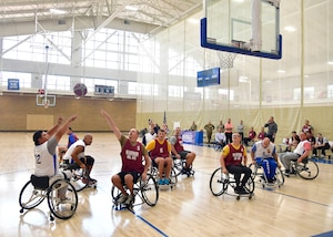 Players in wheelchairs gather around a hoop during the basketball game.