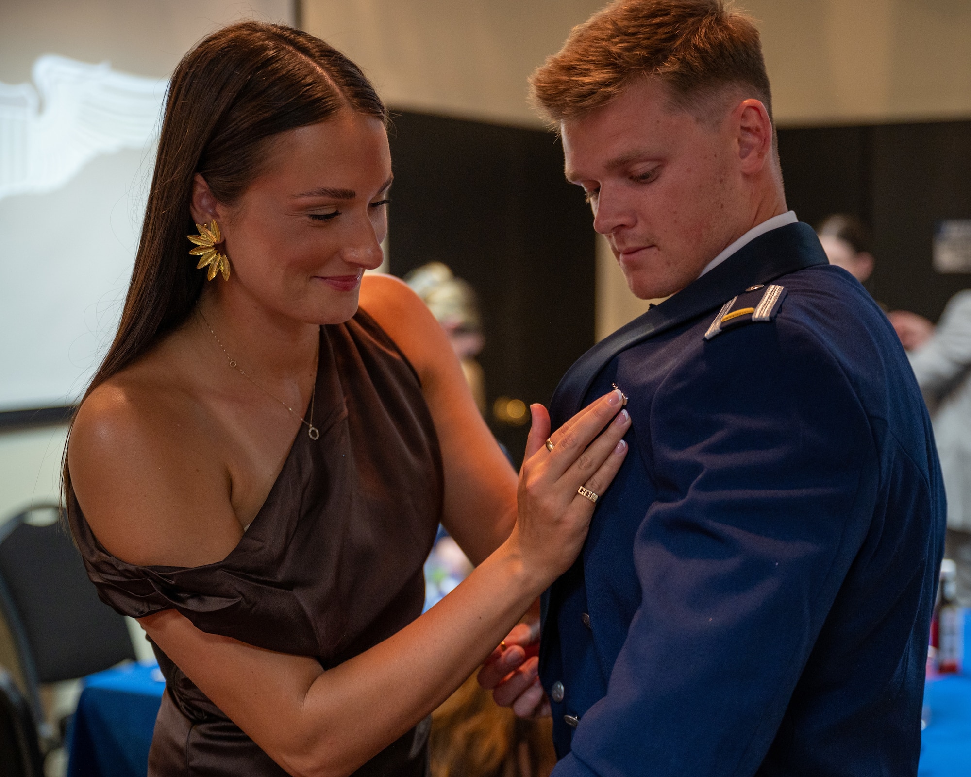 A familiy member pins the wings on a recently graduated pilot at Laughlin Air Force Base, Texas, Nov. 1, 2024. (U.S. Air Force photo by Staff Sgt. Nicholas Larsen)