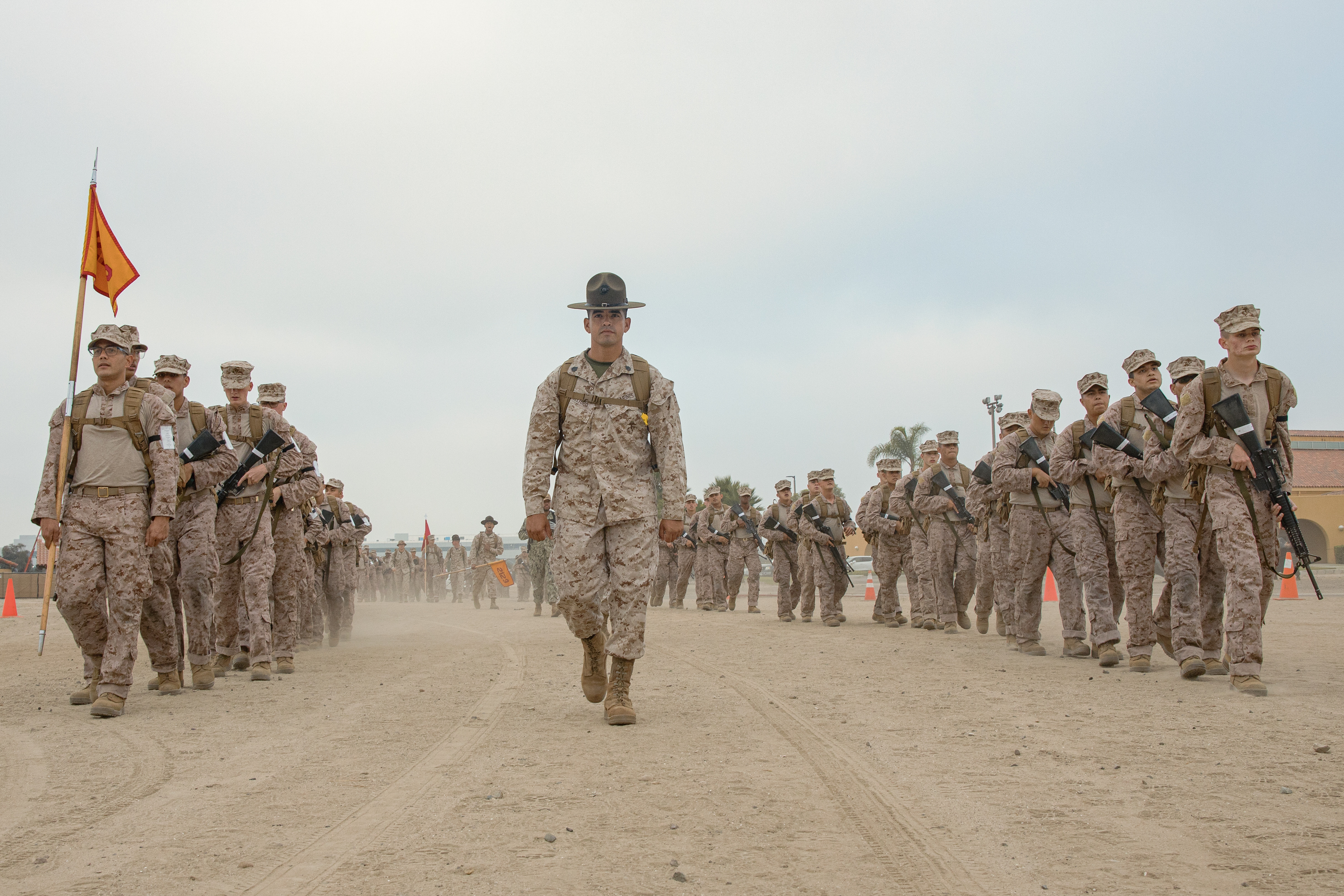 U.S. Marine Corps Staff Sgt. Deltoro, a senior drill instructor with Fox Company, 2nd Recruit Training Battalion, leads recruits during a two-kilometer introduction hike at Marine Corps Recruit Depot San Diego, California, Oct. 10, 2024. During training, recruits conduct a series of progressively longer hikes to physically and mentally condition them to create combat readiness for any necessary future operations as the world’s force in readiness.  (U.S. Marine Corps photo by Cpl. Sarah M. Grawcock)