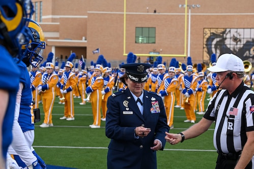 U.S. Air Force Col. Angelina Maguinness, 17th Training Wing Commander takes part in the coin flip at the beginning of the annual Angelo State University Military Appreciation game at the 1st Community Credit Union Field at LeGrand Stadium, San Angelo, Texas, Nov. 2, 2024. In football, a coin toss before each game decides which team gets the first possession and which side of the field they will start on. (U.S. Air Force photo by Airman 1st Class James Salellas)