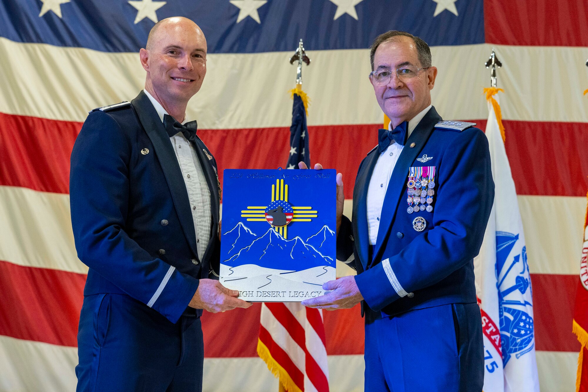 U.S. Air Force Col. John Ethridge, 49th Wing Commander, left, gives a plaque to retired Lt. Gen. Marc Rogers, Inspector General of the Air Force, during the 2024 Holloman Air Force Ball at Holloman Air Force Base, New Mexico, Nov. 2, 2024.