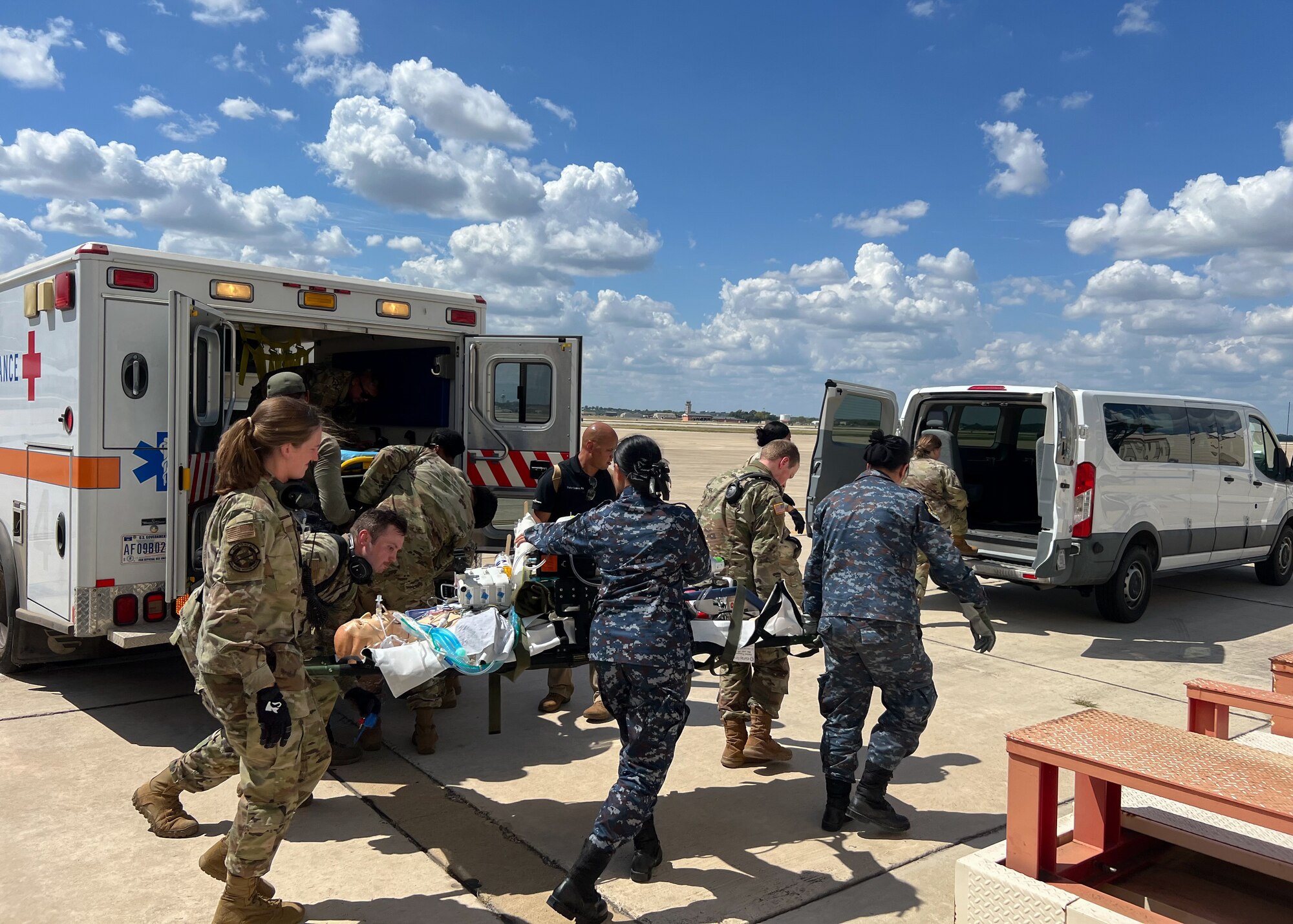 Royal Thai Air Force nurses assist U.S. Air Force medical personnel during a patient transport training exercise on the flight line at Kelly Airfield in San Antonio, Texas.