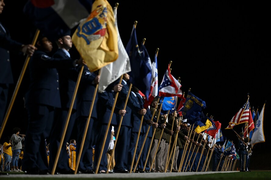 U.S. joint service members bear the U.S. State flags and the Goodfellow Air Force Base Joint Service Color Guard presents each service flag during the halftime show of the Angelo State University Military Appreciation Game at the 1st Community Credit Union Field at LeGrand Stadium, San Angelo, Texas, Nov. 2, 2024. During the halftime show, the ASU Ram Band played through each service song to honor those who have served. (U.S. Air Force photo by Airman 1st Class Madi Collier)