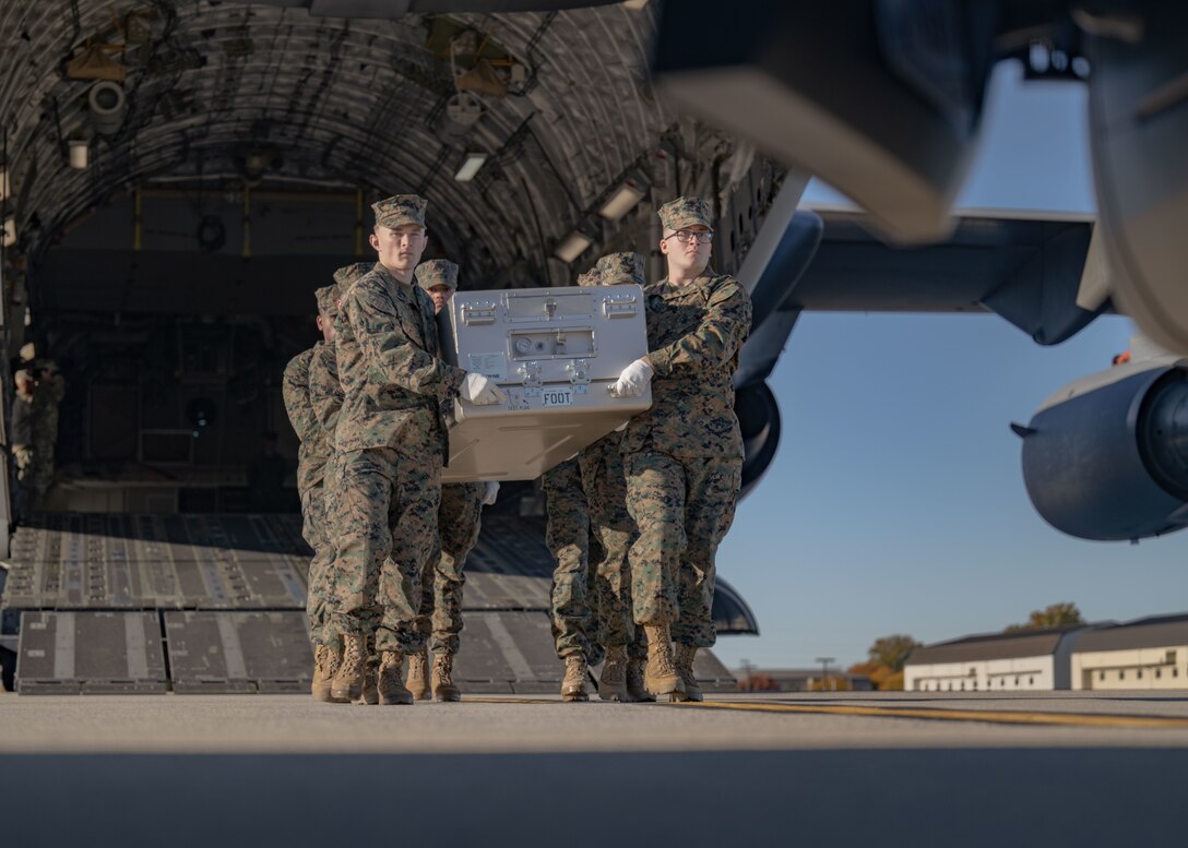 A group of Marines carries a transfer case to an awaiting transfer vehicle during a dignified transfer ground training.