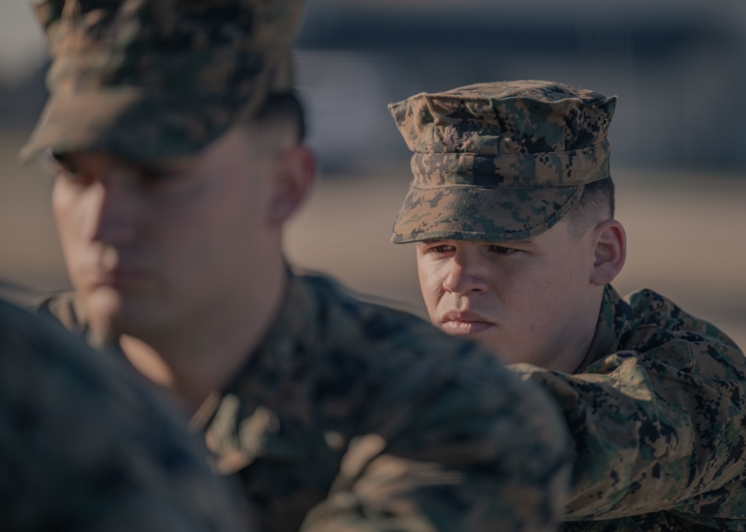 A Marine waits as another Marine secures a transfer case inside of a transfer vehicle.