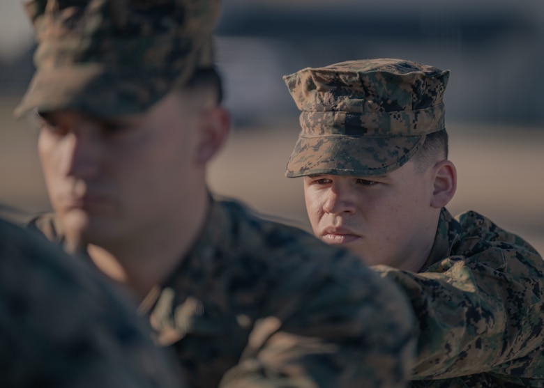 A Marine waits as another Marine secures a transfer case inside of a transfer vehicle.