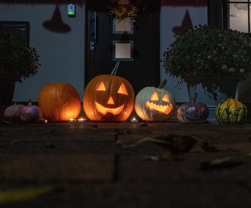 Carved pumpkins sit outside a house in base housing.