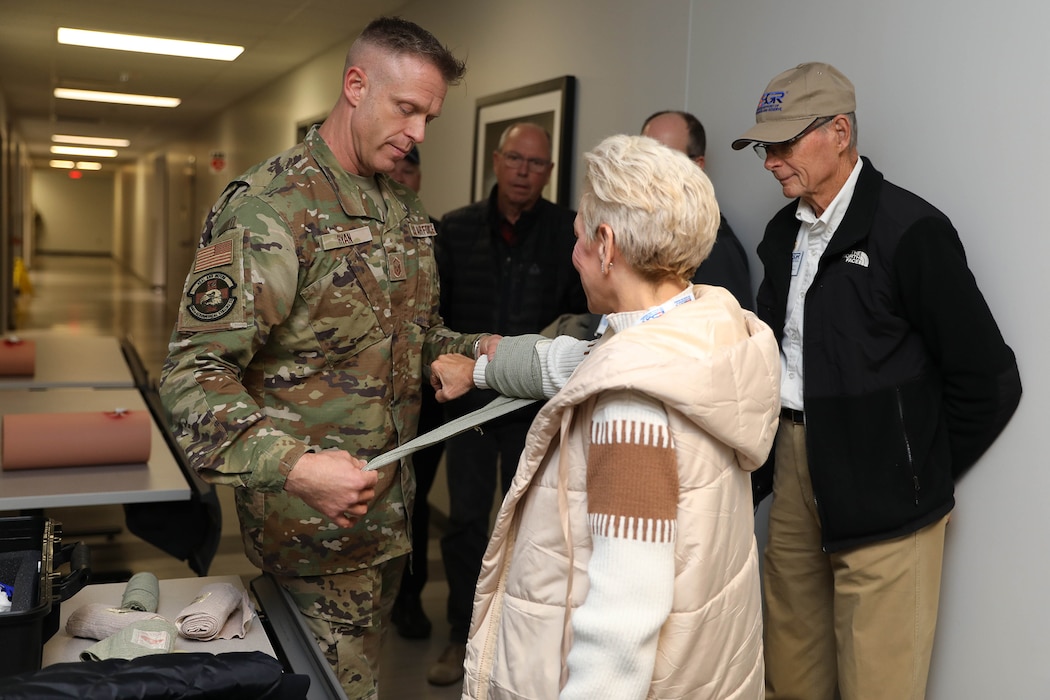 Master Sgt. Todd Ryan, 445th Aeromedical Staging Squadron tactical combat casualty care program director, applies pressure bandage to an employer during TCCC demonstration at Wright-Patterson Air Force Base Nov. 2, 2024. The wing hosted more than 40 employers for an Employer Appreciation Day which gave them the opportunity to learn about the wing’s operations and concluded with a flight on a C-17 Globemaster III. (U.S Air Force photo/Senior Airman Angela Jackson)