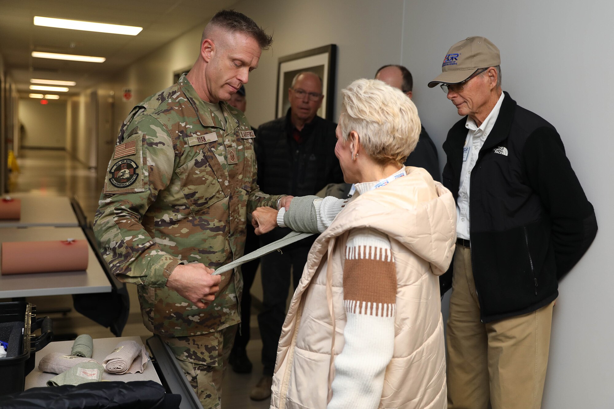 Master Sgt. Todd Ryan, 445th Aeromedical Staging Squadron tactical combat casualty care program director, applies pressure bandage to an employer during TCCC demonstration at Wright-Patterson Air Force Base Nov. 2, 2024. The wing hosted more than 40 employers for an Employer Appreciation Day which gave them the opportunity to learn about the wing’s operations and concluded with a flight on a C-17 Globemaster III. (U.S Air Force photo/Senior Airman Angela Jackson)