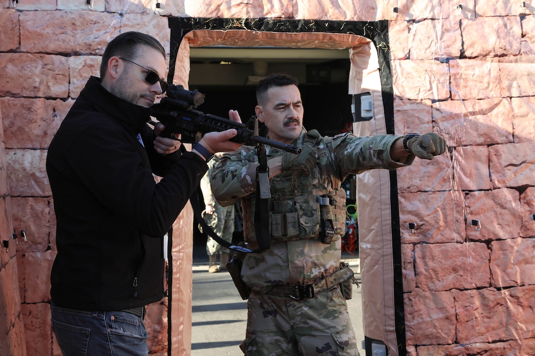 Tech. Sgt. Joel Ford, 445th Security Forces Squadron fire team leader, gives guidance to an employer during building clearing exercise as part of the many events that took place for the 445th Airlift Wing Employer Appreciation Day Nov. 2, 2024 During the SFS demonstration, employers were shown how to shoot, move and communicate through a building to eliminate a potential threat.. (U.S Air Force photo/Senior Airman Angela Jackson)