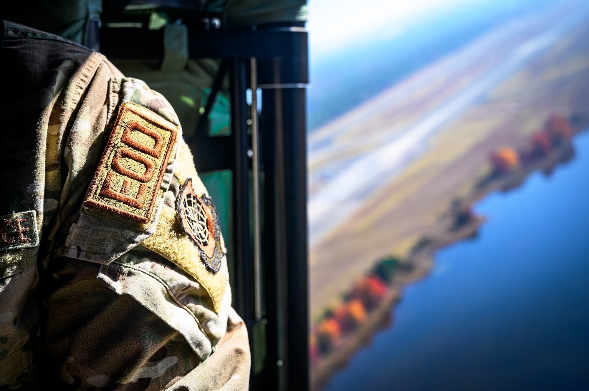 U.S. Air Force Tech. Sgt. Moises Gonzalez, 87th Civil Engineer Squadron explosive ordinance technician, is transported on a Sikorsky UH-60 Black Hawk helicopter during Operation Honey Badger at Joint Base McGuire-Dix-Lakehurst, N.J., Oct. 22, 2024. Operation Honey Badger is a simulated deployment where civil engineers were tasked to establish and defend a base camp from potential enemies. The New Jersey Army National Guard provided aerial support to assist with sling load operations for the aviators and loadmasters participating in the exercise. (U.S. Air Force photo by Senior Airman Matt Porter)