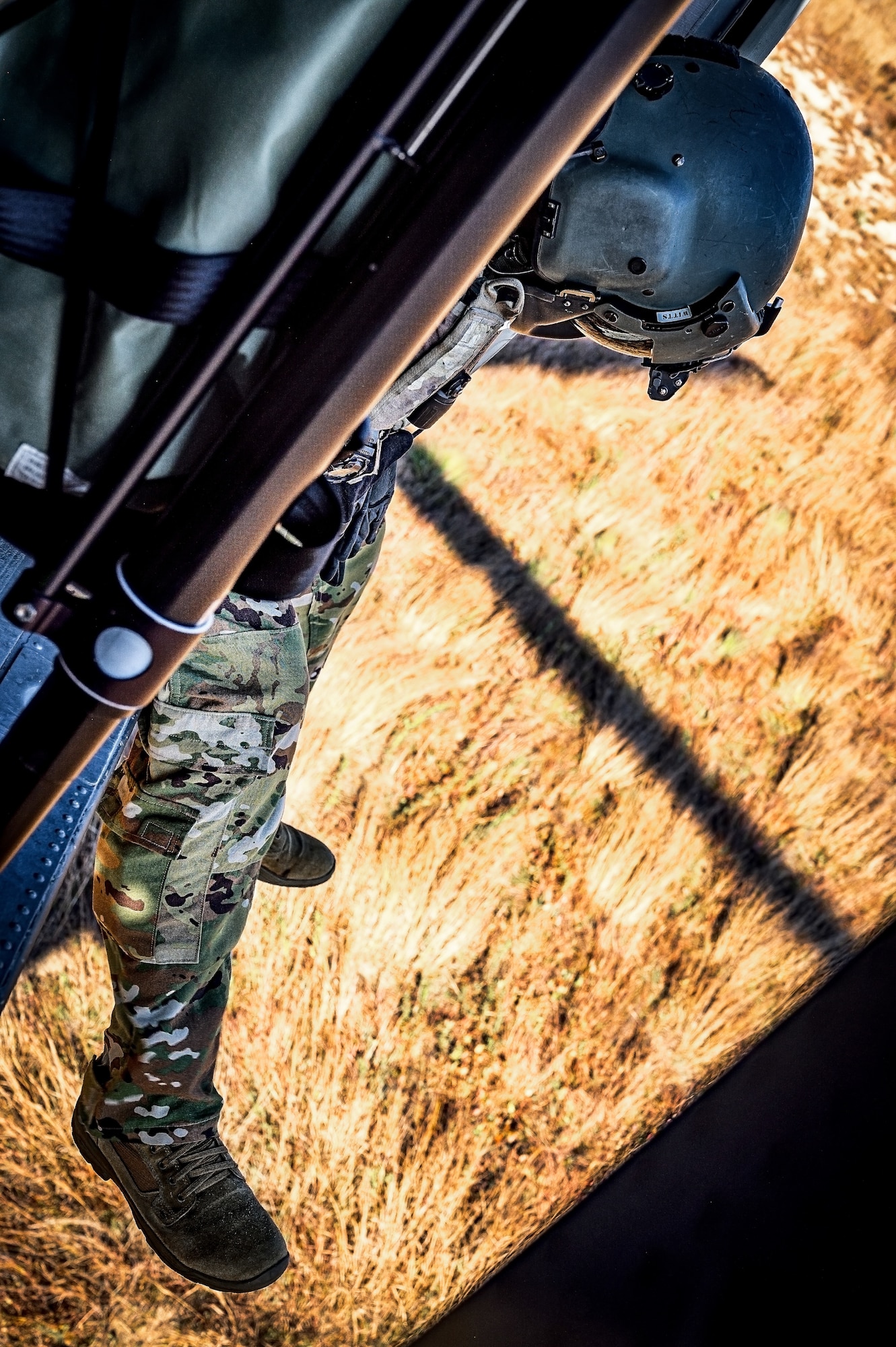 U.S. Army Sgt. 1st Class Timothy Watts, 1st Battalion 150th Aviation Regiment crew chief, prepares to land on a Sikorsky UH- 60 Black Hawk helicopter during Operation Honey Badger at Joint Base McGuire-Dix-Lakehurst, N.J., Oct. 22, 2024. Operation Honey Badger is a simulated deployment where civil engineers were tasked to establish and defend a base camp from potential enemies. The New Jersey Army National Guard provided aerial support to assist with sling load operations for the aviators and loadmasters participating in the exercise. (U.S. Air Force photo by Senior Airman Matt Porter)