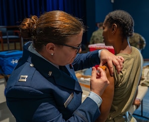 A 920th Aeromedical Staging Squadron clinical nurse, administers a dose of the influenza vaccine to a 920th Rescue Wing Airman