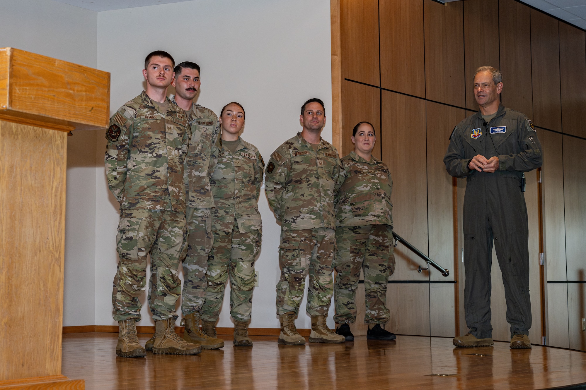 Airmen stand on stage