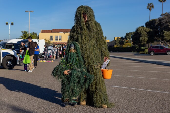 U.S. Marine Corps Gunnery Sgt.  Elkan Meyer, drill instructor with 1st Recruit Training Regiment and his son, pose for a photo during the Marine Corps Recruit Depot San Diego annual Trunk-or-Treat event at MCRD San Diego, California, Oct. 25, 2024.  The trunk-or-treat event gives the Marines, Sailors, civilians and their families an opportunity to dress up and collect candy in a safe and controlled environment. (U.S. Marine Corps photo by Lance Cpl. Jacob B. Hutchinson)