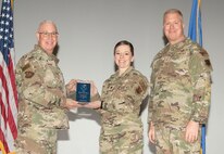 U.S. Air Force Col. Harley P. Thompson, left, commander of the 99th Mission Support Group (MSG), and Chief Master Sgt. Scott Castrovinci, Senior Enlisted Leader of the 99th MSG, right, present the Field Grade Officer of the Quarter award to Maj. Brianna Oltman, director of operations assigned to the 99th Contracting Squadron, during the third quarter awards at Nellis Air Force Base, Nevada, Oct. 29, 2024.