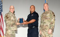 U.S. Air Force Col. Harley P. Thompson, left, commander of the 99th Mission Support Group (MSG), and Chief Master Sgt. Scott Castrovinci, right, Senior Enlisted Leader of the 99th MSG, present the Category I Civilian of the Quarter award to Sean Villa-Gomez, a fire protection civilian assigned to the 99th Civil Engineer Squadron, during the third quarter awards at Nellis Air Force Base, Nevada, Oct. 29, 2024.