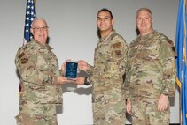 U.S. Air Force Col. Harley P. Thompson, left, commander of the 99th Mission Support Group (MSG), and Chief Master Sgt. Scott Castrovinci, right, Senior Enlisted Leader of the 99th MSG, present the Airman of the Quarter award to Senior Airman Cameron Wilson, a cyber security technician assigned to the 99th Communications Squadron, during the third quarter awards at Nellis Air Force Base, Nevada, Oct. 29, 2024.